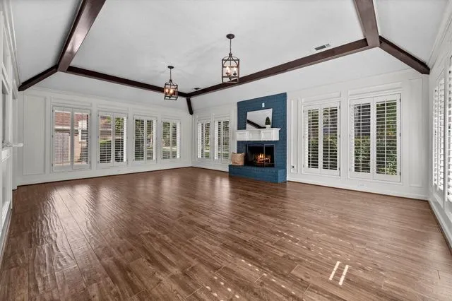 Living room with ceiling beams, wood floors and fireplace at 9527 Enstone Circle