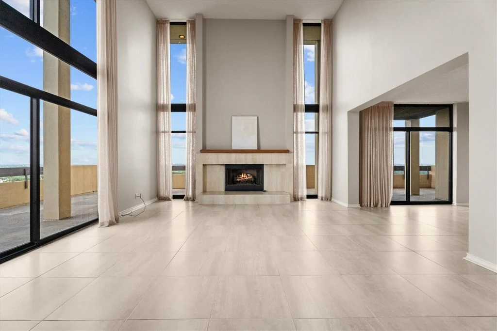 Double-height living room with a fireplace and tall windows at Timber Top #1801